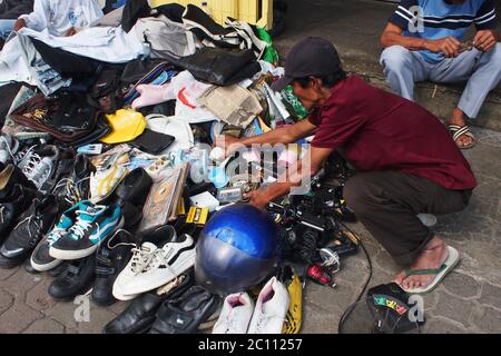 Bogor, West Java, Indonesia - 28 dicembre 2013 : UN potenziale acquirente sembra essere alla ricerca di beni usati venduti sul marciapiede Foto Stock