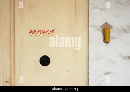 Bogor, Giava Occidentale, Indonesia - 28 dicembre 2013 : una vecchia porta con le parole della preghiera nel buddismo Foto Stock