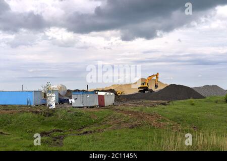 Escavatore giallo lavorando a scavare nella cava di sabbia Foto Stock