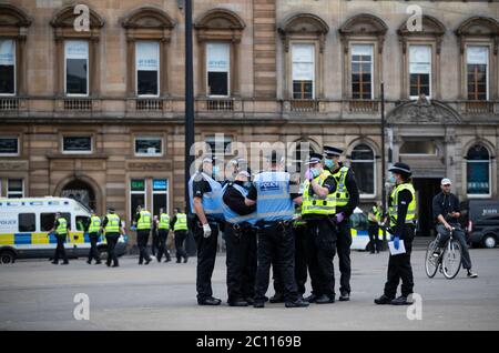 La polizia in pattuglia mentre gli attivisti si riuniscono al cenotafio di George Square, Glasgow, per proteggerlo da qualsiasi attacco di vandalismo dopo che la Lega di Difesa Loyalist ha chiesto ai seguaci di riunirsi per un evento 'Proteggi il Cenotafh' in risposta alle statue che vengono deaffrontate in tutta la Scozia dopo le dimostrazioni della materia Black Lives. Foto Stock