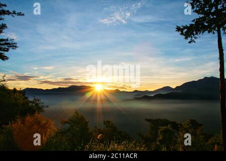 Vista del tramonto sulle montagne con nebbia al piano terra al mattino. Alishan National Forest Recreation Area nella contea di Chiayi, Alishan Township, Taiwa Foto Stock