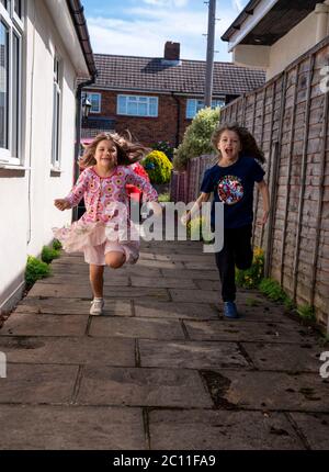 RITRASMETTERE AGGIUNGENDO COGNOMI DI ETÀ NON DATI Emily 10 (a destra) e Daisy 7 in esecuzione per vedere la loro nonna ad Ashtead, Surrey, per la prima volta dopo l'introduzione di misure per portare l'Inghilterra fuori blocco, come le persone che vivono da soli in Inghilterra possono formare bolle di sostegno con altre famiglie da sabato, settimane di isolamento concluse sotto blocco. Foto Stock