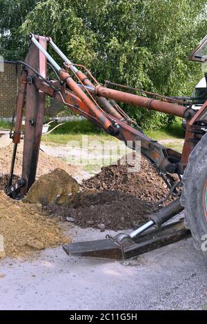 Benna dell'escavatore che scava una trincea nel terreno sporco Foto Stock
