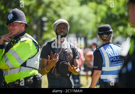 Brighton UK 13 giugno 2020 - UN protettore parla con un ufficiale di collegamento della polizia mentre migliaia di persone prendono parte al raduno di protesta contro il razzismo della Black Lives Matter attraverso Brighton Today . Ci sono state proteste in tutta America , Gran Bretagna e altri paesi dalla morte di George Floyd mentre è stato arrestato dalla polizia a Minneapolis il 25 maggio : Credit Simon Dack / Alamy Live News Foto Stock