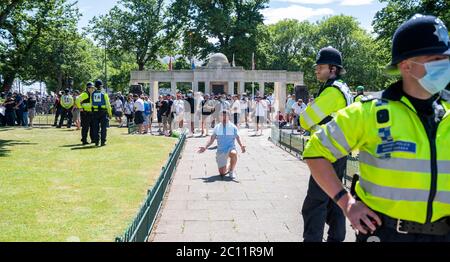 Brighton UK 13 giugno 2020 - uno degli uomini creduto di far parte di gruppi di destra scende al ginocchio al memoriale di guerra, mentre al memoriale di guerra migliaia di persone prendono parte al raduno di protesta contro il razzismo Black Lives Matter attraverso Brighton Today . Ci sono state proteste in tutta America , Gran Bretagna e altri paesi dalla morte di George Floyd mentre è stato arrestato dalla polizia a Minneapolis il 25 maggio : Credit Simon Dack / Alamy Live News Foto Stock