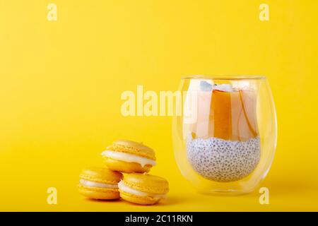 Budino di mango con semi di chia in vetro su sfondo giallo Foto Stock