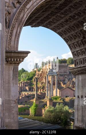 Le antiche colonne rovinate del tempio di Castor e Pollux appaiono attraverso la porta dell'Arco di Severus, monumento del Foro Romano, Roma, Ita Foto Stock