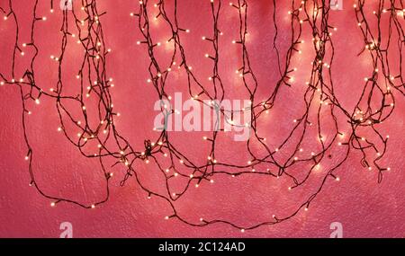 Ghirlanda di Natale di lampadine su sfondo rosso. Foto Stock