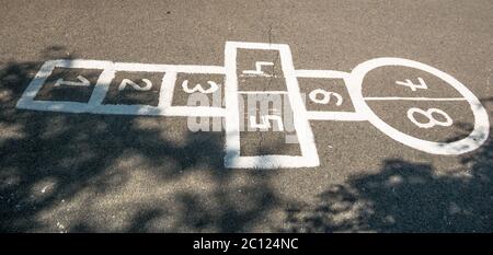 Gioco per bambini hopscotch dipinto sul pavimento. Foto Stock