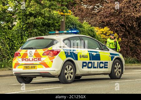 Macchina della polizia con ufficiale che dirige il traffico Foto Stock