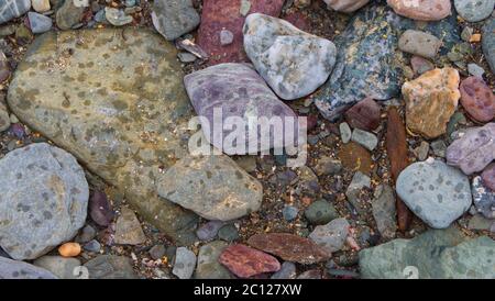 Sfondi testurari di ciottoli da spiaggia, rocce e sabbia lungo la linea di trefolo di una spiaggia riparata Cornovaglia. Foto Stock