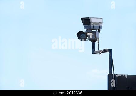 Telecamera CCTV in cielo che guarda le persone sulla strada Foto Stock