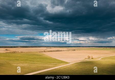 Vista aerea. Incredibile cielo naturale drammatico con nuvole di pioggia sopra la campagna campo rurale paesaggio in primavera giorno. Cielo panoramico con nuvole soffici Foto Stock