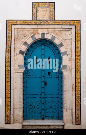 Porta decorata in modo elaborato di una casa tradizionale a Sidi bou Said, Tunisia, in stile moresco con arcate e piastrelle intarsiate Foto Stock