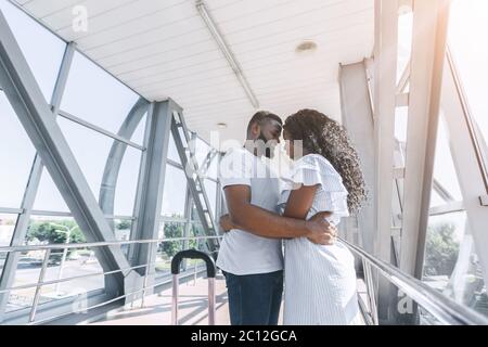 Una coppia afroamericana in amore per coccolarsi nel corridoio dell'aeroporto Foto Stock