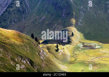 luce del sole sulle colline di montagna e lago alpino Foto Stock