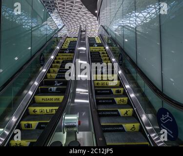 Le scale mobili stanno inarcando i messaggi covid alla stazione ferroviaria di Kings Cross a Londra. Foto Stock