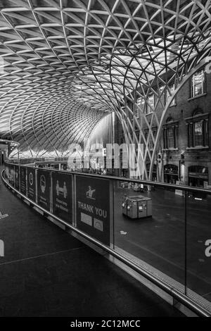 Immagine monocromatica di una stazione ferroviaria internazionale di Kings Cross vicina a quella vuota a Londra durante il blocco. Foto Stock