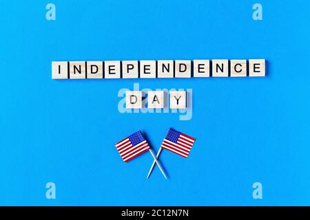 Independence Day iscrizione in lettere di legno su sfondo blu. Buon giorno di Indipendenza. Il 4 luglio. Giornata dell'indipendenza degli Stati Uniti. Bandiere americane. Co Foto Stock