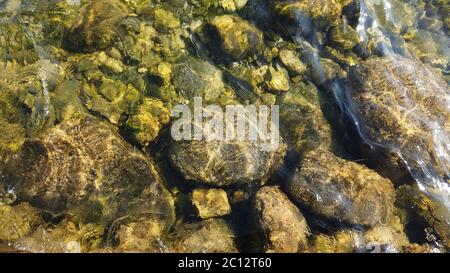 Le trame dell'acqua mostrano pietre nell'acqua Foto Stock