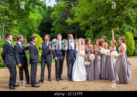 Foto di gruppo della sposa e dello sposo con tutti gli sposi e le cameriere d'onore. Matrimonio britannico a South Cambridgeshire, Inghilterra Foto Stock