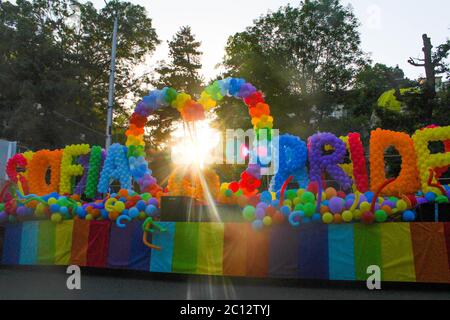 Giornata della Parata dell'orgoglio gay 2019 a Sofia. Colorato camion rosso con palloncini a tema LGBTQ arcobaleno con raggi di sole nel mezzo del cuore palloncino. Foto Stock