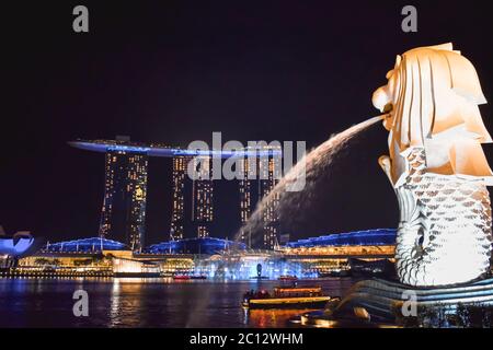 Vista notturna illuminata dell'hotel Marina Bay Sands dalla statua di Merlion Foto Stock
