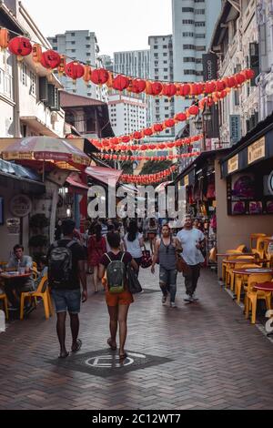 Persone che camminano su una strada con lanterne decorative di carta a Singapore China Town Foto Stock