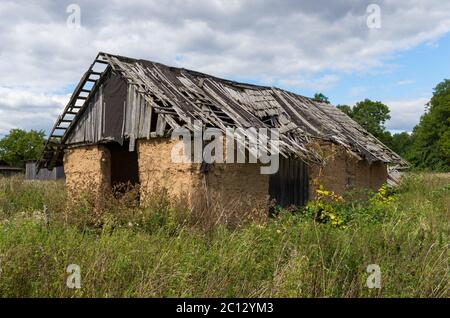 Fatiscenti vecchia fattoria shack in un campo Foto Stock