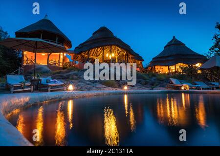 Le luci dell'hotel si riflettono nella piscina del lussuoso boutique hotel Mihilo Lodge nel Parco Nazionale del Lago Mburo Uganda Foto Stock