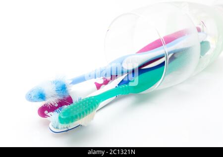 Vecchio utilizzati gli spazzolini da denti colorati in un bicchiere Foto Stock