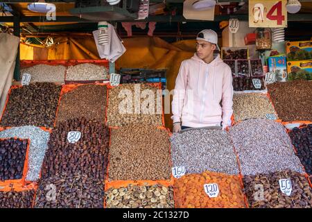 Marrakech, Marocco: Un uomo al mercato alimentare di strada in luogo Jemaa el-fna vendere frutta secca e noci Foto Stock