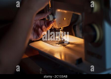 Mano della donna che lavora su una macchina da cucire Foto Stock