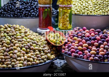 Olive in vendita al mercato all'aperto di strada cibo mercato sulla piazza principale di Place Djemaa El Fna a Marrakech Marocco di notte Foto Stock
