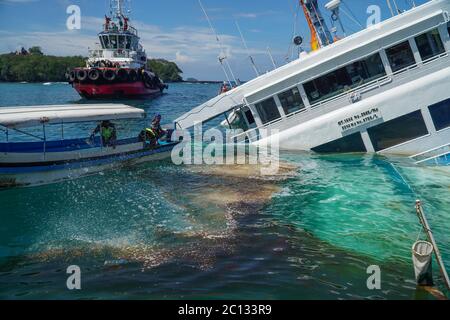 Karangasem, Bali, Indonesia. 13 Giugno 2020. Imbarcazione più piccola spargere il disperdente di olio intorno. Misure di evacuazione dei passeggeri traghetto (KMP) Dharma Rucitra III dall'isola di Lombok che ha scaldato al porto di Padangbai il venerdì (06/03) notte. Credit: Dicky Bisinglasi/ZUMA Wire/Alamy Live News Foto Stock