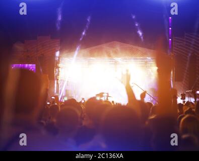 Sagome di concerto la folla di fronte luminose luci da palco Foto Stock