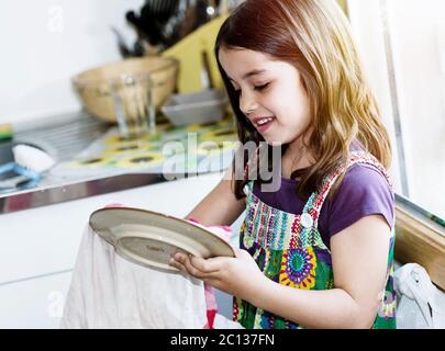 ragazza molto carina bambino che pulendo i piatti Foto Stock