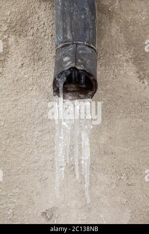Il vecchio tubo di scarico con acqua congelata Foto Stock