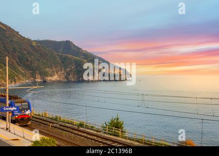 Tramonto sulle cinque Terre mentre il treno si dirige verso la stazione ferroviaria di Corniglia, sulla costa italiana Foto Stock