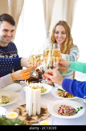 Gli amici tostano con champagne mentre si cena di Natale Foto Stock
