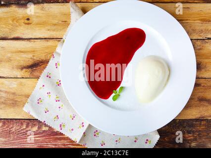 Panna cotta dessert italiano con un sorrup di lamponi Foto Stock