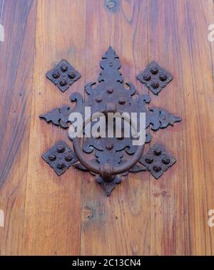 Elegante ornamentale vecchio battente di metallo su porta di legno stagionato. Foto Stock