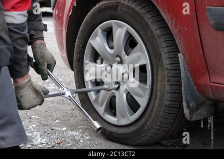 montaggio della ruota dell'auto passeggero e sostituzione dello pneumatico invernale. Foto Stock