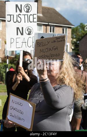 Slough, Regno Unito. 13 giugno 2020. Una donna ha un segno che porta il nome di Belly Mujinga, un operaio ferroviario che è morto con COVID-19 dopo essere stato sprat da un uomo che sostiene di avere coronavirus, durante una protesta pacifica in solidarietà con il movimento Black Lives Matter a Salt Hill Park. La polizia dei trasporti britannici ha deciso che l’attacco alla stazione di Victoria non ha portato alla morte di Mujinga. Credit: Mark Kerrison/Alamy Live News Foto Stock