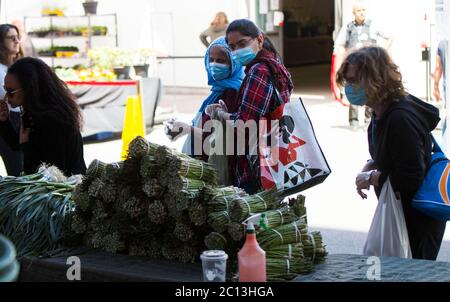 Toronto, Canada. 13 Giugno 2020. Le persone che indossano maschere facciali negozio in un mercato all'aperto a Toronto, Canada, il 13 giugno 2020. Alcuni mercati agricoli a Toronto riaprirono sabato in mezzo alla pandemia COVID-19. Credit: Zou Zheng/Xinhua/Alamy Live News Foto Stock