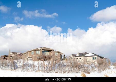 Città soleggiata situata sul pendio innevato delle montagne di Wasatch in inverno Foto Stock