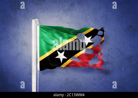 Bandiera strappata di Saint Kitts e Nevis che vola contro sfondo grunge Foto Stock
