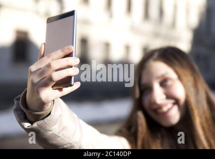 Bellissima bruna giovane donna che prende un selfie con smartphone. Foto Stock