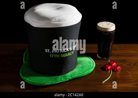 St Patrick giornata con una pinta di birra nera, cappello e shamrock Foto Stock