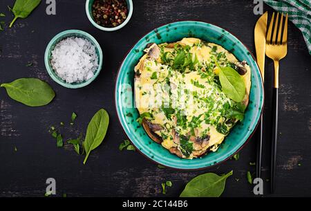 Spinaci e frittata di funghi. Frittata composta da uova, funghi e spinaci. Cucina italiana. Vista dall'alto, disposizione piatta, spazio per la copia Foto Stock